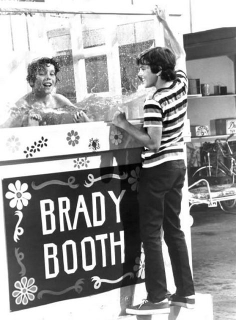 Photo of Mike Lookinland (Bobby) and Christopher Knight (Peter) from the television program The Brady Bunch. Bobby is trying out a dunk tank Peter has built for the school carnival.