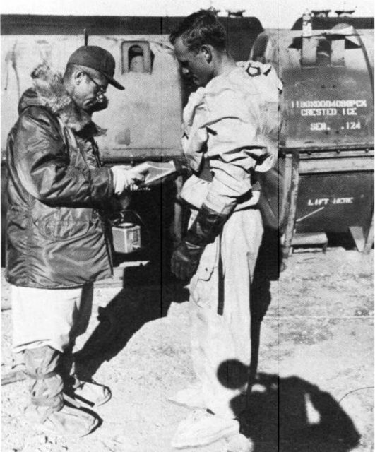 A monitor checks a pump operator for radioactive contamination during Project Crested Ice.