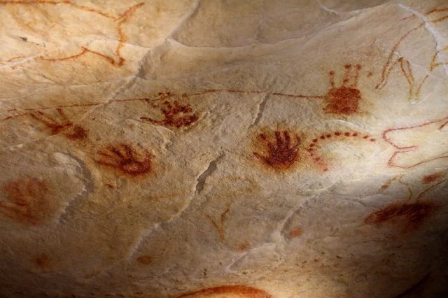 Hands (including a trace of a curved little finger: this character is found in various places in the cave), enigmatic signs, red and yellow drawings. Pont d’Arc cave (copy of the Chauvet Cave). Photo by Claude Valette CC BY-SA 4.0