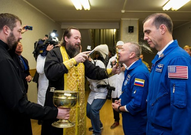 Expedition 38 Soyuz Commander Mikhail Tyurin of Roscosmos receives the traditional blessing from a Russian Orthodox priest at the Cosmonaut Hotel prior to launch.