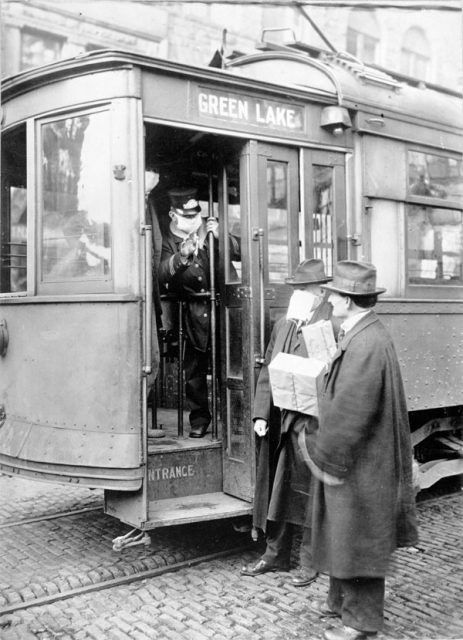 A street car conductor in Seattle in 1918 refusing to allow passengers aboard who are not wearing masks.