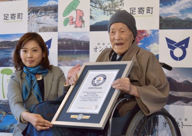 Masazo Nonaka of Japan (R), aged 112, receives a certificate for the Guinness World Records’ oldest male person living-Nonaka was born on July 25, 1905. Photo by JIJI PRESS / JIJI PRESS / AFP/Getty Images