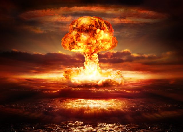 Nuclear bomb blast over the ocean with mushroom cloud.