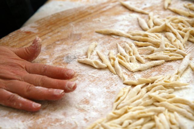 Italian pasta, strozzapreti homemade on wooden table.