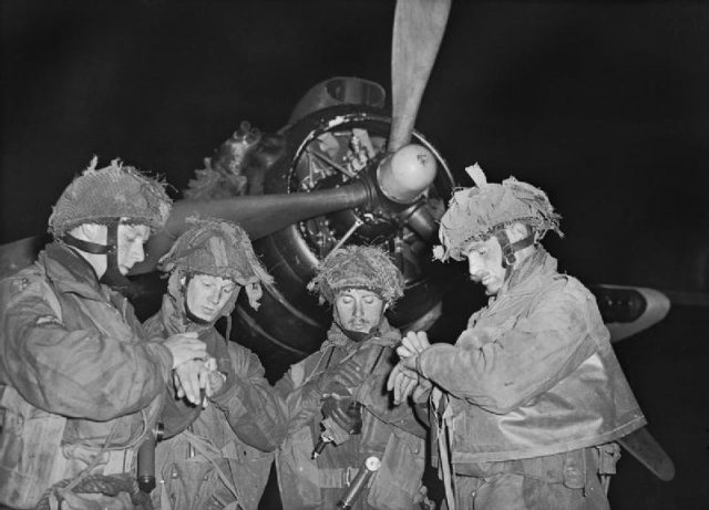 D-DAY 6 JUNE 1944. The Final Embarkation: Four ‘stick’ commanders of 22nd Independent Parachute Company, British 6th Airborne Division, synchronising their watches in front of an Armstrong Whitworth Albemarle of No 38 Group.
