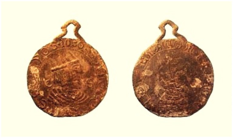 A lead Billy and Charley medallion. One side shows the profile head of a man wearing a crown; the other shows the head of a helmeted knight. The medallion is dated 