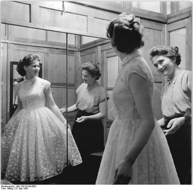 High necklines and plenty of lace would remain popular until the late 1960s. Bundesarchiv, Bild 183-53194-0001 Wittig CC-BY-SA 3.0