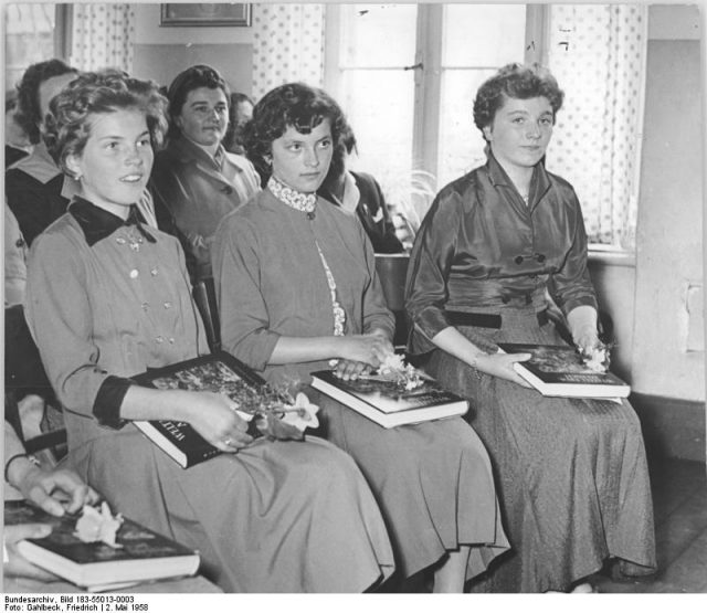 Two ladies in the front row have chosen outfits with contrasting velvet features that echo the Neo-Edwardian Teddy Boy style. Photo by Bundesarchiv, Bild 183-55013-0003 – CC-BY-SA 3.0
