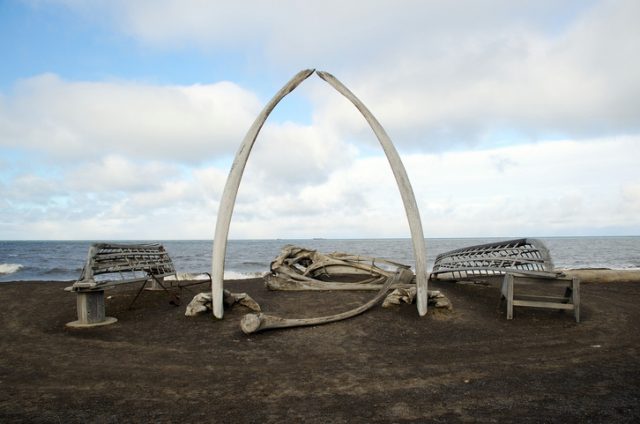 An arctic gateway of sorts to Barrow, Alaska made of Bowhead whale bones and whaling boat frames through which a view of the Chukchi Sea and passing Oil Tankers can be seen.