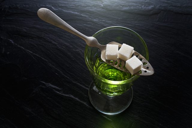 Absinthe in pontarlier glass and spoon with sugar cubes