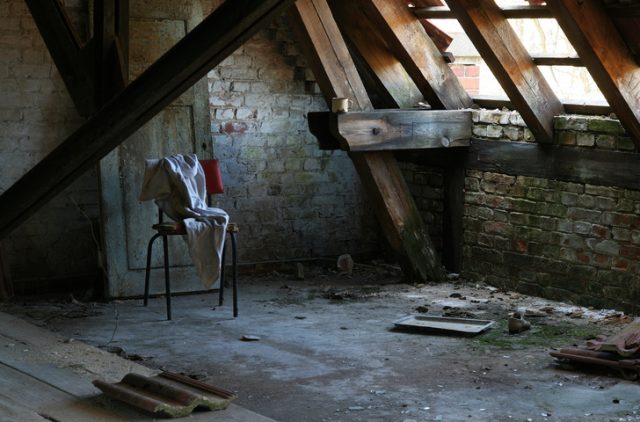 Mysterious chair and stained clothes in an abandoned attic