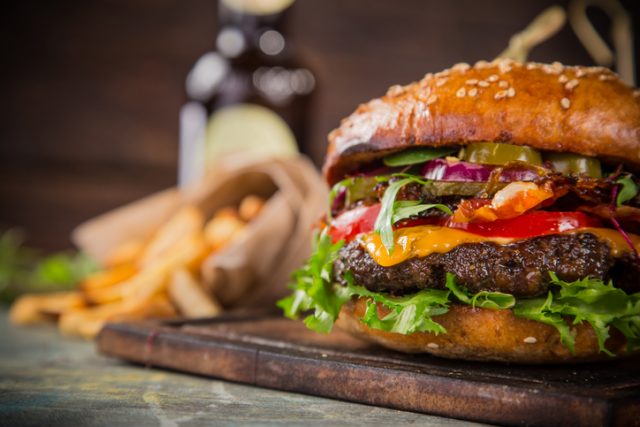 Close-up of home made tasty burgers on wooden table.