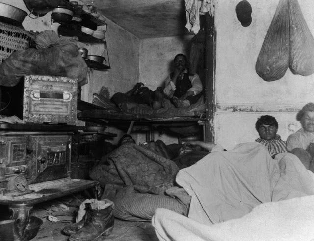 Shelter for immigrants in a Bayard Street tenement, where a group of men share one room, Lower East Side, 1885.