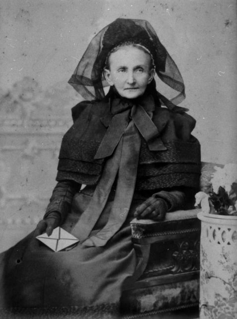 Elderly woman, possibly dressed in mourning clothes, 1890-1900.