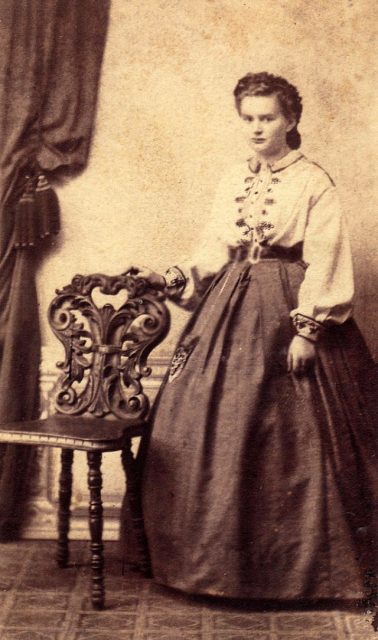 Teenage girl posing next to a chair