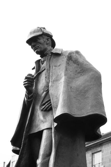 Statue of Holmes in an Inverness cape and a deerstalker cap on Picardy Place in Edinburgh (Conan Doyle’s birthplace) Photo by Siddharth Krish. CC BY-SA 3.0