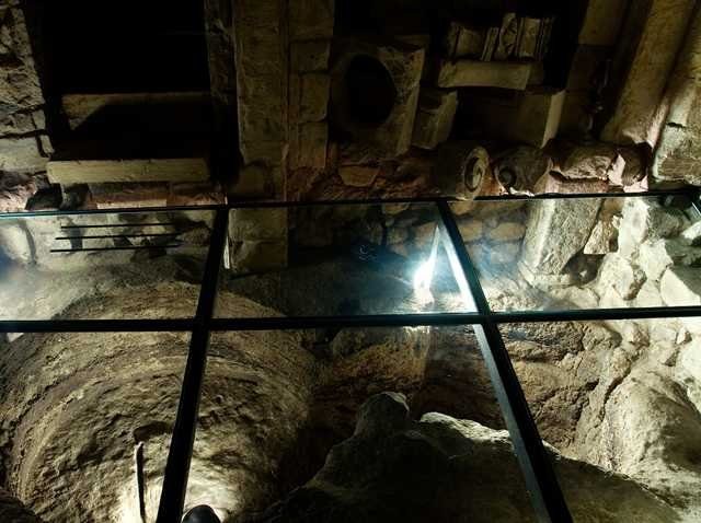 Glass floors allow visitors to look down into cellars, tombs, the well, secret hiding spaces and narrow underground passageways. Photo by Museo Faggiano