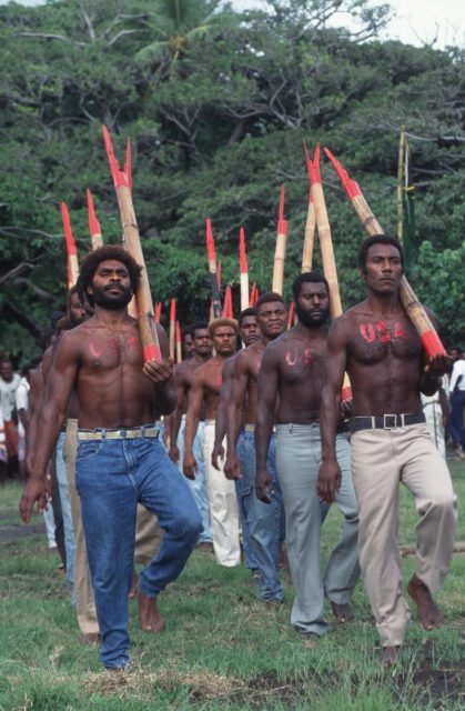 Young Melanesian men with ‘USA’ painted in red on their bodies stage a military parade with fake guns. They believe that they are a kind of elite force within the American army. Photo by Thierry Falise/LightRocket via Getty Images