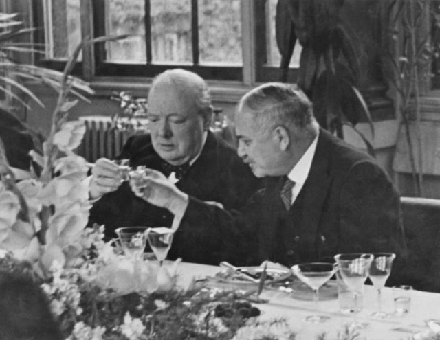 British Prime Minister Winston Churchill (left) clinks glasses with Soviet Ambassador Ivan Maisky at a lunch party given by the ambassador for representatives of all the Allied governments, in the Winter Garden of the Soviet Embassy in London, August 1941.