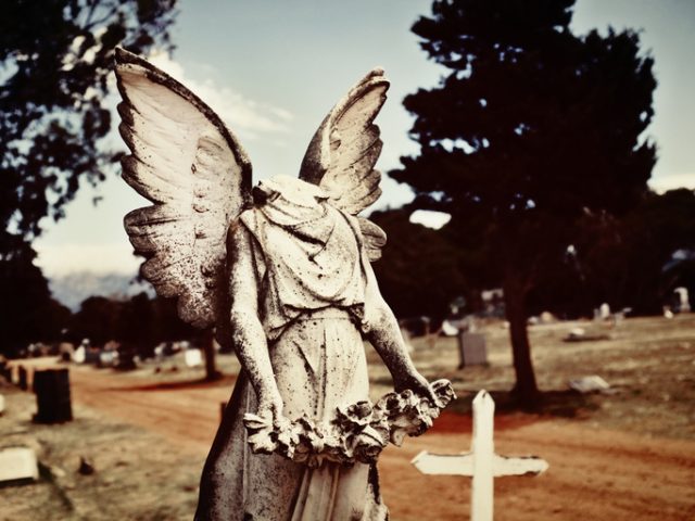 Early 20th century vandalized statue of an angel has lost her head.