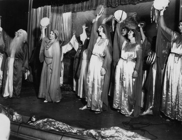 Minister Aimee Semple McPherson and a group of tambourine players leading a service at Angelus Temple. She was very innovative in producing weekly dramas illustrating religious themes.