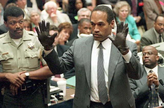 OJ Simpson holding up his hands in the middle of a courtroom