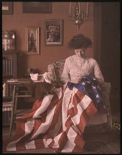 Woman sewing a United States flag.