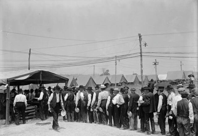Men lined up outside of a tent