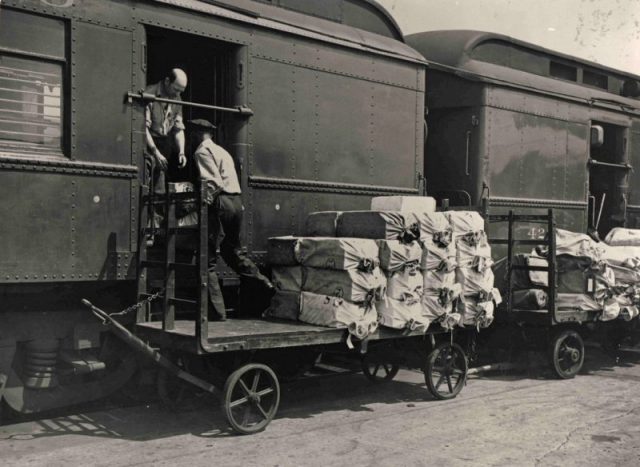 Loading mail onto a railway Post Office car.