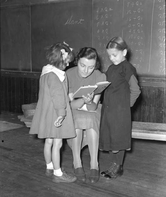An English and Amish girl are tutored by their non-Amish teacher in 1938 in Lancaster County, PA.