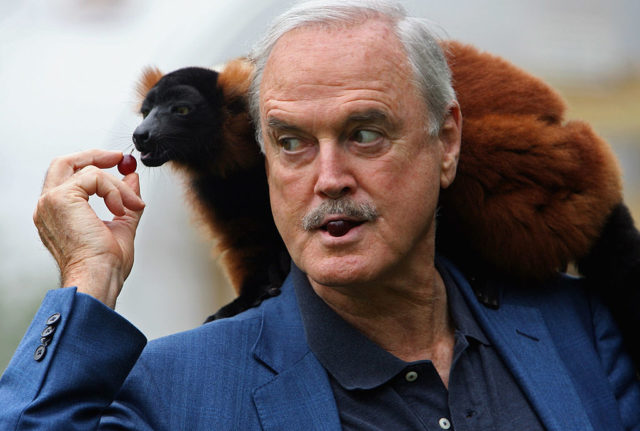 John Cleese feeding an animal at the zoo