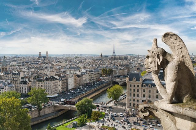 Gargoyle and wide city view from the roof of Notre Dame de Paris, France