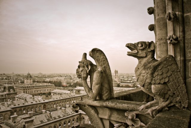 Monochrome photograph of the Cathedral of Paris with gargoyles.