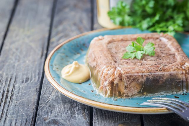 Traditional homemade jelly meat with mustard and horseradish on the table.