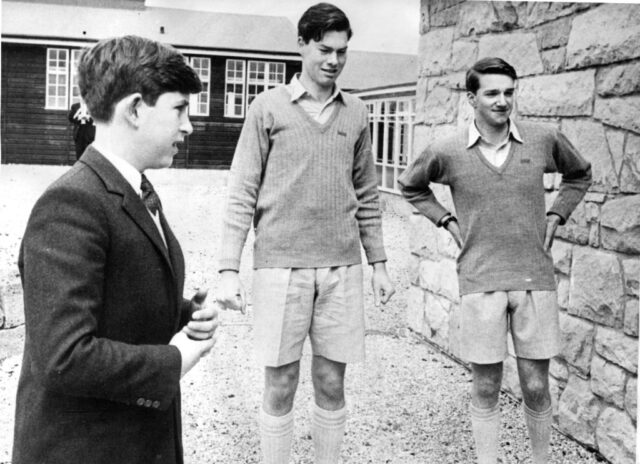 Then-Prince Charles standing with Peter Paice and Dougal McKenzie on the grounds of Gordonstoun