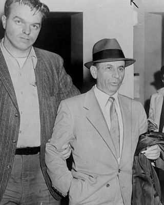 Meyer Lansky being led by detective for booking on vagrancy charge at 54th Street police station, New York City…