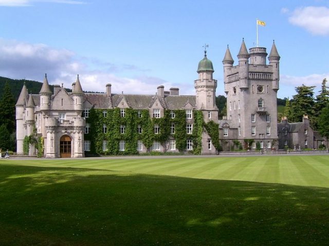 Balmoral Castle. The Royal Standard of Scotland flies over it. Photo by Stuart Yeates from Oxford, UK -CC BY-SA 2.0