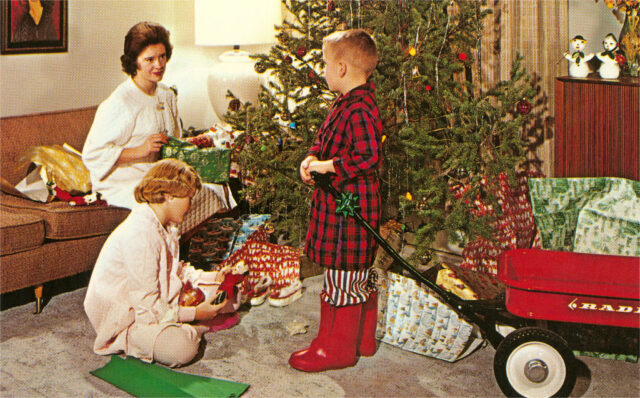 Children opening Christmas presents with their mother