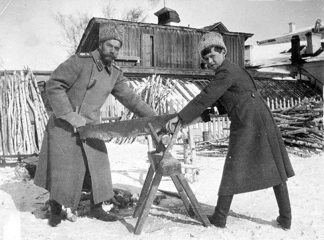 Tsar Nicholas and his son Alexei sawing wood while in exile.