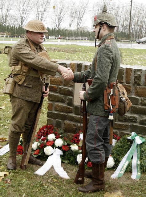 Re-enactors Peter Knight and Stefan Langheinrich, descendants of Great War veterans, shake hands at the 2008 unveiling of a memorial to the 1914 Christmas Truce. Photo by Alan Cleaver CC BY 2.0