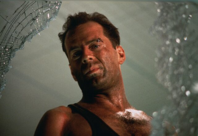 Bruce Willis looking through broken glass.