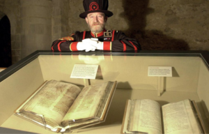 Tom Sharp standing over a glass case containing the Domesday Book
