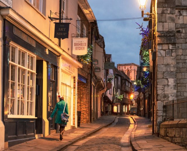 York, UK – A woman walking along Shambles, one of the best known historical streets in Europe.