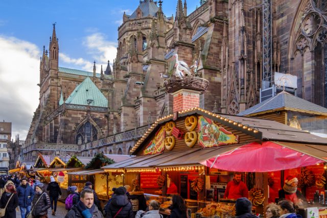 People at the Christmas market in Place de la Cathédrale of Strasbourg, considered the capital of the historical region of Alsace. The city is the official seat of the European Parliament.