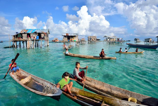 Semporna, Sabah, Malaysia – April 19, 2015: Crowds of Bajau paddle boats near their village in Bodgaya Island, Semporna, Sabah, Malaysia. Boat is the main transportation in the area.