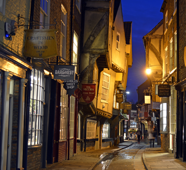 The Shambles in heart of the city of York, England has changed very litle since it was first built hundreds of years ago and is visited by thousands of tourists every week of the year. Taken just after dark to show the street and window lights of the shops.