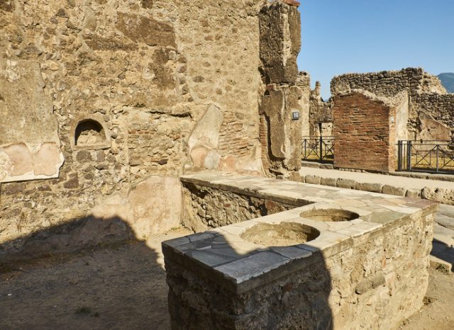 Taberna D. Juni Proculi (D. Junius Proculus) at Ruins of Pompeii. The city was an ancient Roman city destroyed by the volcano Vesuvius. Pompei, Campania, Italy.