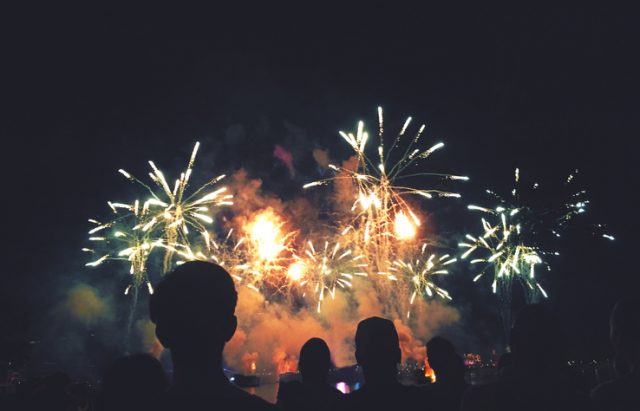 Crowd of Silhouetted People Watching a Colorful Fireworks Display 