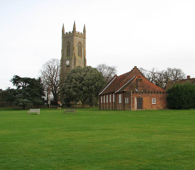 View of Salle Church, behind trees and a cricket ground