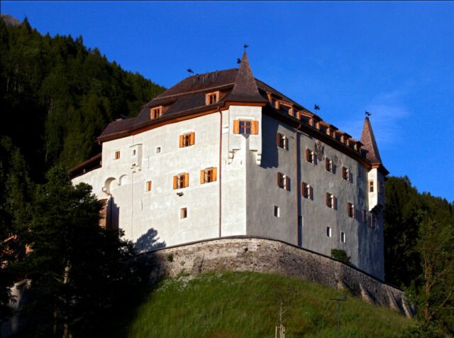 The outside of a castle on a hill.
